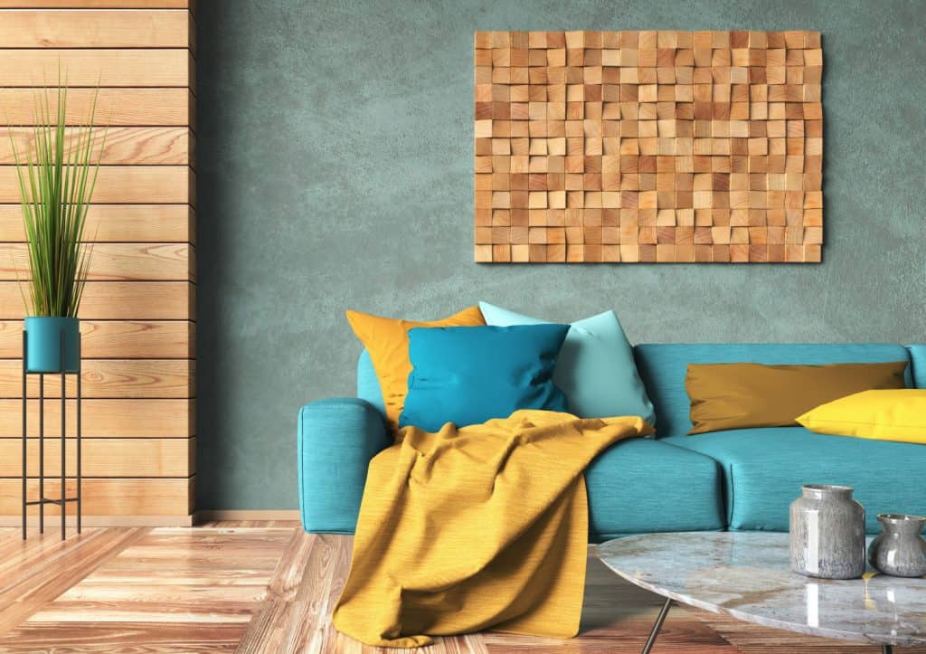 Vibrant modern living room with colorful cushions, wooden wall decor, and cozy throw blanket, showcasing affordable decorating ideas from Decorating for Less.