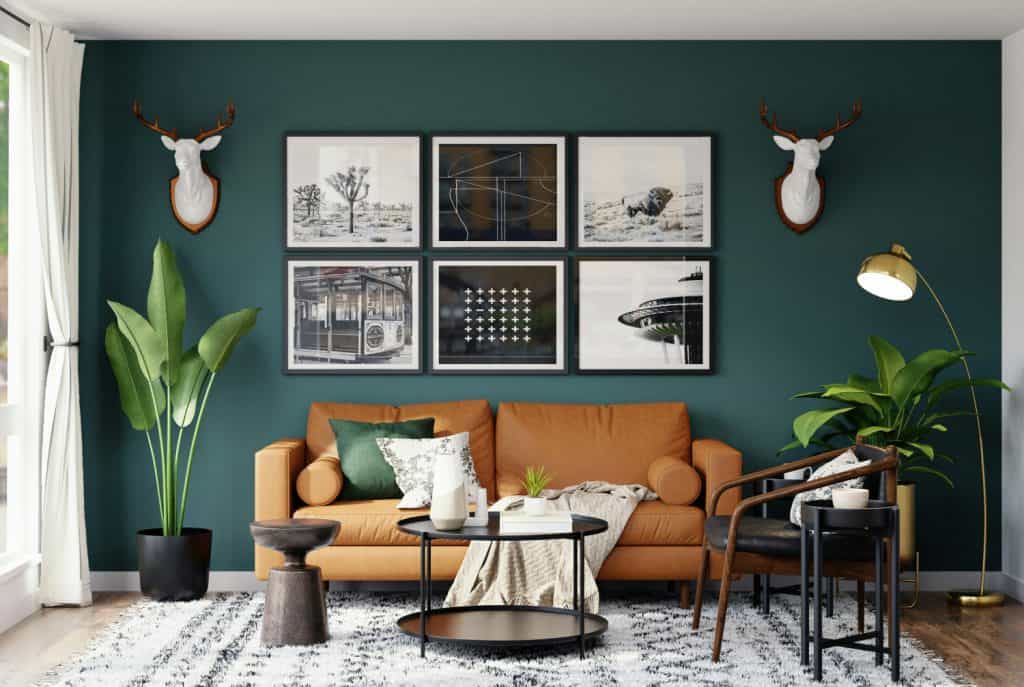 Modern living room interior with teal accent wall, stylish black and white artwork, and cozy caramel sofa, complemented by vibrant green plants and trendy lighting for an inviting home decor look.